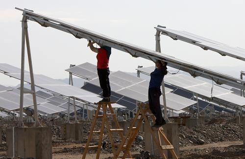 6月11日,工人在新疆哈密光伏發(fā)電站安裝太陽能電池板組件。新華社發(fā)(普拉提 攝)