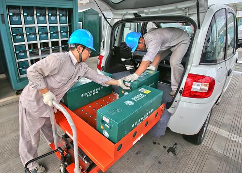 8月30日,在浙江金華東關(guān)電動(dòng)汽車充電站內(nèi),兩名工作人員在給市民的純電動(dòng)汽車更換標(biāo)準(zhǔn)電池。新華社發(fā)(王平 攝)