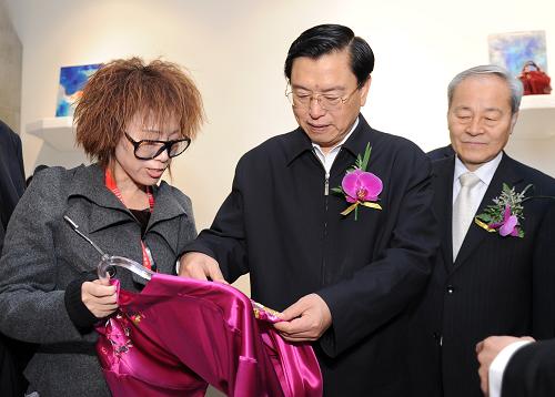 3月29日,中共中央政治局委員、國務院副總理張德江參觀第19屆中國國際服裝服飾博覽會。這是張德江在展臺內(nèi)向工作人員了解服裝面料的使用情況。 新華社記者王曄攝