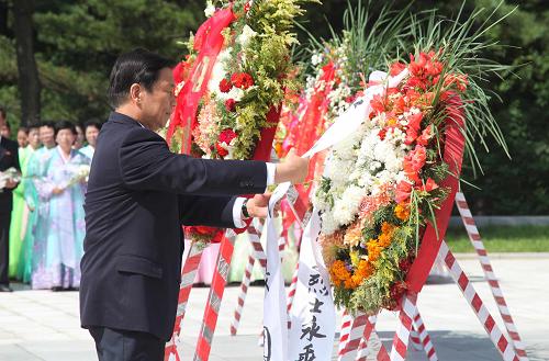 7月26日,國家副主席李源潮在朝鮮檜倉中國人民志愿軍烈士陵園整理花圈緞帶。 正在朝鮮訪問并出席朝鮮戰(zhàn)爭停戰(zhàn)60周年紀(jì)念活動的國家副主席李源潮當(dāng)天在平壤參謁友誼塔,并前往檜倉中國人民志愿軍烈士陵園,憑吊烈士。 新華社記者 張利 攝