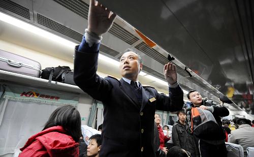 1月8日,長沙開往上海的旅客列車上出現(xiàn)“學生潮”,一名乘務員在其中整理行李架。 新華社記者 趙眾志 攝