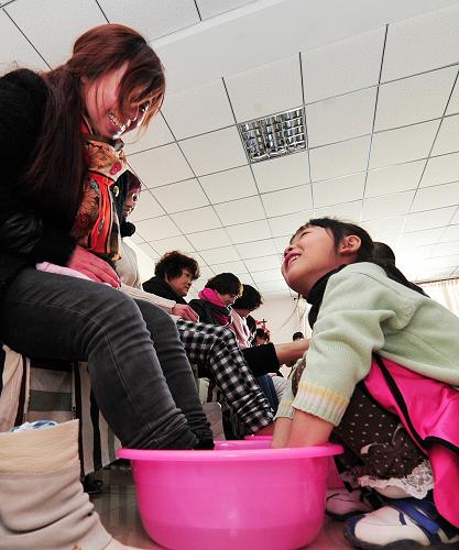 3月8日,在銀川興慶區(qū)長城花園社區(qū),孩子們在為母親洗腳。當(dāng)日是“三八”國際勞動(dòng)?jì)D女節(jié),寧夏回族自治區(qū)銀川市長城花園社區(qū)開展“婦女節(jié)感恩”系列活動(dòng),社區(qū)的孩子們?yōu)槟赣H洗腳、按摩,并送上用自己的零花錢購買的康乃馨,在節(jié)日里為母親送去一份祝福。新華社記者 彭昭之 攝