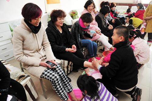 3月8日,在銀川興慶區(qū)長城花園社區(qū),孩子們在為母親洗腳。新華社記者 彭昭之 攝