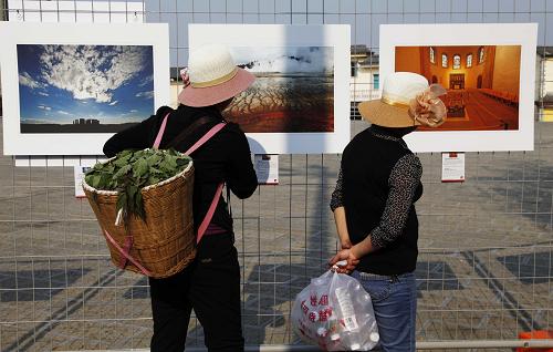 3月17日,人們在攝影展上觀看新華社推出的“用我們的眼睛帶你看世界遺產(chǎn)”展覽。新華社記者 高靜 攝
