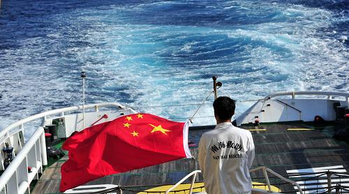 3月18日,水手李國(guó)棟在南海救101輪船甲板后部升起國(guó)旗。新華社記者 趙穎全 攝