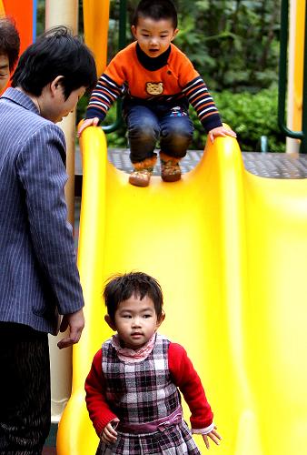 4月2日,一些小朋友在家長的看護下在上海街頭公共綠地內(nèi)玩耍。新華社記者 陳飛 攝