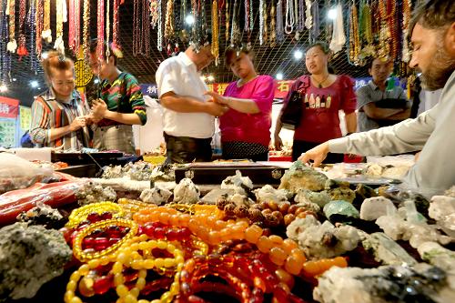 6月2日,游客在奇石博覽會(huì)上購買飾品。新華社發(fā)(蔡增樂 攝)