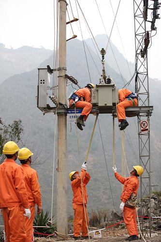 1月28日,電網工人在廣西河池市大化縣一村屯安裝配電變電器。新華社發(fā)(潘方強 攝)