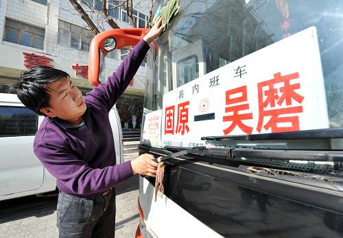 1月30日,司機師傅在發(fā)車前擦洗車窗玻璃。這是一輛從寧夏固原市市區(qū)開往彭堡鎮(zhèn)吳磨村的城鄉(xiāng)班車。一年一度的春運開始后,在寧夏西海固地區(qū)固原市原州區(qū),一趟趟行駛在農(nóng)村公路上的公交車迎來客運高峰。春運期間,僅固原市原州區(qū)每天就有600余個班次的農(nóng)村公交車往返行駛,每天都要為12000多位乘客服務。在一趟從市區(qū)到彭堡鎮(zhèn)吳磨村的城鄉(xiāng)公交車上,記者了解到,這趟車途經(jīng)6個村莊,20多個??奎c。“現(xiàn)在大部分都是回村里過節(jié)的人,還有進城買年貨的。”售票員一邊售票一邊告訴記者。整個行程大約30公里左右,票價也從1元到5元不等。班車途經(jīng)頭營鎮(zhèn)后,大部分乘客都陸續(xù)下車了,班車也沒有急著走。“在流量比較大的站點要多等一會兒,因為錯過這一班,就要等很久了。”售票員一邊喝水一邊說:“很多人都是靠著我們這班車趕回家過年的。”新華社記者 彭昭之 攝