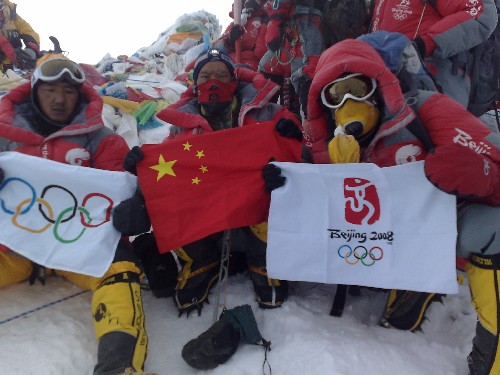 5月8日,北京奧運圣火珠峰傳遞登山隊成功登頂珠峰。這是登山隊員在峰頂展示中國國旗、奧運五環(huán)旗和北京奧運會會徽旗。 新華社特約記者阿旺扎西攝