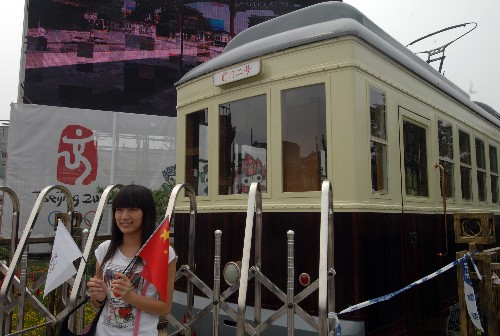 8月7日,一位女孩在前門(mén)有軌電車(chē)鐺鐺車(chē)前拍照。由于奧運(yùn)期間前門(mén)大街有馬拉松等賽事活動(dòng),鐺鐺車(chē)暫不運(yùn)行。當(dāng)日,北京前門(mén)大街正式開(kāi)街。北京前門(mén)大街北起前門(mén)月亮灣,南至珠市口,全長(zhǎng)840米。自2007年5月9日開(kāi)始,前門(mén)大街開(kāi)始了大規(guī)模修繕整治工程。此前的幾年里,修繕?lè)桨腹步?jīng)過(guò)了16位文物專(zhuān)家32次專(zhuān)業(yè)論證。 新華社記者金良快攝