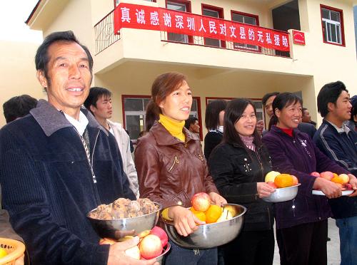11月11日,在甘肅隴南災(zāi)區(qū)第一批完成重建的重建村之一文縣尖山鄉(xiāng)宋家壩村,群眾給援建者送上蘋果、核桃等土特產(chǎn),以表感激之情。截至目前,甘肅省隴南地震災(zāi)區(qū)551個災(zāi)后恢復(fù)重建村有540個開工重建,其中104個村2831戶建成主體工程,有3767戶已竣工。新華社記者 屠國璽 攝