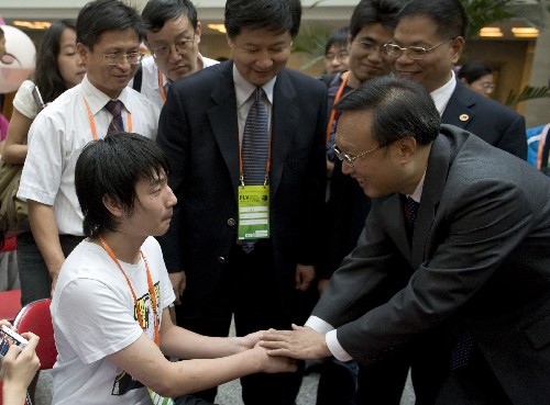 2008年9月13日,外交部部長楊潔篪與“勇敢的夾縫男孩”、北川中學學生廖波握手。 新華社記者 金良快 攝