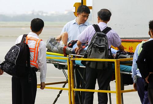 5月13日,工作人員準(zhǔn)備將葉志棠送上飛機(jī)。當(dāng)日,在臺(tái)灣受傷游客葉志棠從臺(tái)北乘坐兩岸直航包機(jī),返回廣東繼續(xù)療養(yǎng)。4月24日,來自廣東的一個(gè)旅行團(tuán)在乘車前往臺(tái)北市101大樓參觀途中,被從樓頂墜落的起重機(jī)吊臂砸中車尾,造成3人死亡,葉志棠在事故中受傷。新華社發(fā)(吳景騰 攝)