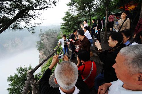 游客在張家界天子山景區(qū)內(nèi)觀光(5月15日攝)。2009年以來(lái),隨著一系列促進(jìn)旅游經(jīng)濟(jì)發(fā)展讓利政策的出臺(tái),世界自然遺產(chǎn)、世界地質(zhì)公園張家界風(fēng)景名勝區(qū)逐步實(shí)現(xiàn)了旅游業(yè)的恢復(fù)性增長(zhǎng)。據(jù)悉,張家界2009年一季度旅游總?cè)舜螢?97.28萬(wàn),旅游總收入為12.05億元,與2008年同比分別增長(zhǎng)9.07%和10%。新華社記者 龍弘濤 攝