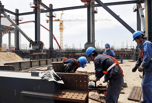 5月18日,施工人員在華電寧夏靈武二期工程現(xiàn)場施工。新華社記者 劉泉龍 攝