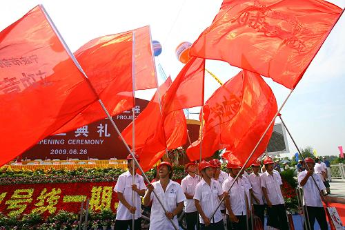 6月26日,建設(shè)者在寧波軌道交通1號(hào)線一期工程世紀(jì)大道站工地舞動(dòng)彩旗迎接開工。新華社發(fā)(張培堅(jiān) 攝)