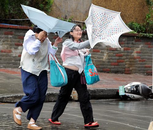 8月7日,臺(tái)風(fēng)“莫拉克”帶來(lái)強(qiáng)風(fēng),臺(tái)北街頭市民的雨傘被吹翻。據(jù)臺(tái)灣氣象部門(mén)報(bào)告,“莫拉克”臺(tái)風(fēng)中心7日5時(shí)許位于宜蘭東南方約270公里的海面上,由于移動(dòng)速度略為減慢,臺(tái)風(fēng)可能于7日傍晚由花蓮、宜蘭之間登陸。新華社發(fā)(吳景騰 攝)