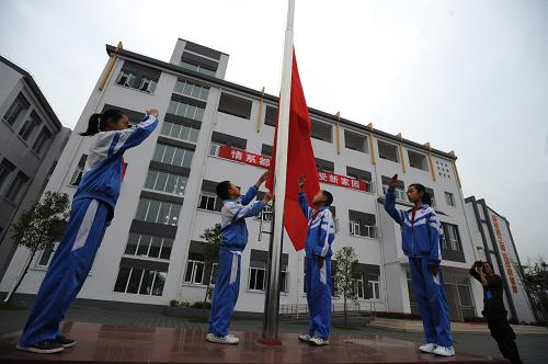5月9日,四川省都江堰市綠地土橋小學(xué)的入學(xué)儀式上舉行升旗儀式。當(dāng)日,由上海援建的都江堰綠地土橋小學(xué)正式竣工交付并舉行入學(xué)儀式。這是都江堰災(zāi)區(qū)第一所開工建設(shè)、第一所交付使用的永久性學(xué)校,同時也是上海對口援建都江堰工程中最早竣工的項目。綠地土橋小學(xué)位于都江堰市崇義鎮(zhèn),占地約24畝,總建筑面積約4800平方米,建有教學(xué)樓、圖書室、食堂等7幢建筑,并配有200米標(biāo)準(zhǔn)塑膠跑道、2個羽毛球場和1個籃球場等設(shè)施。該校容納12個班500余名學(xué)生就讀,全部建筑抗震設(shè)防烈度均達(dá)8度。 新華社記者 江宏景 攝