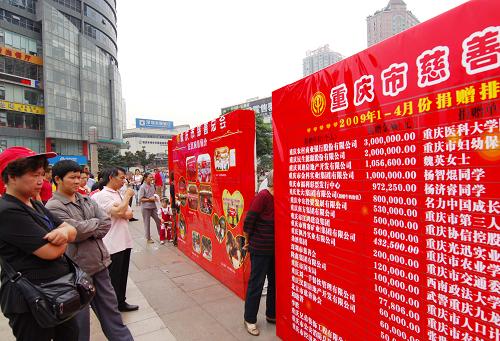 5月9日,幾名重慶市民正在觀看重慶慈善總會(huì)發(fā)布的今年1月至4月重慶的愛心單位和愛心人士表彰榜。 新華社記者 劉潺 攝