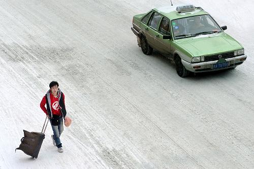 2月11日,一位剛下火車(chē)的旅客在路邊準(zhǔn)備乘出租車(chē)回家。當(dāng)日,雪后的鄭州,火車(chē)站、長(zhǎng)途汽車(chē)站附近仍有不少步履匆匆的趕路人,他們帶著行李或年貨,踏著積雪,趕著回家過(guò)年。 新華社記者 王頌 攝