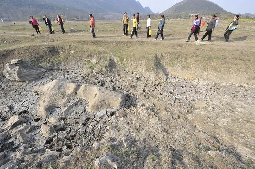 2月26日,當(dāng)?shù)卮迕駨馁F州省貴陽(yáng)市紅楓湖水庫(kù)上游原來(lái)的水淹區(qū)走過(guò)。 新華社發(fā)(吳東俊 攝)