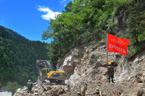 7月27日,挖掘機在坍塌路段作業(yè)。川藏公路波密縣索通村路段26日發(fā)生大面積路基垮塌,導致川藏線中斷。擔負該段養(yǎng)護保通任務的武警交通四支隊迅速啟動應急預案,出動60人和機械車輛8臺,采取集中爆破,雙向掘進的方法進行搶通。經過連續(xù)11個小時的奮戰(zhàn),在路基整體坍塌段兩端已搶修平整便道近40米。據現場搶修指揮員介紹,初步預計還需要1周左右的時間可使垮塌路段恢復通車。 新華社發(fā)(劉云 攝)