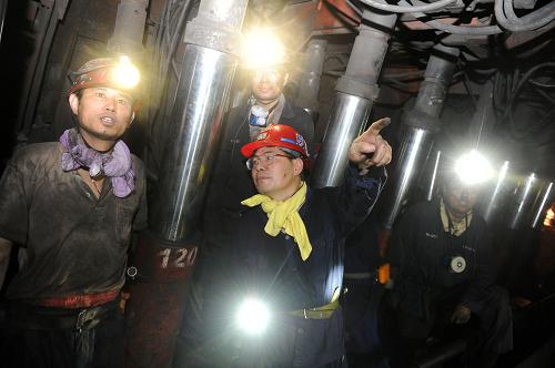 7月28日,皖北煤電集團(tuán)劉橋一礦礦長尹純剛(中)在井下采煤工作面向一線職工了解采煤進(jìn)度和安全生產(chǎn)。 新華社記者 王雷 攝