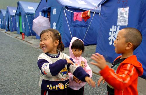 9月8日,在舟曲災后新建的沙川新區(qū),5歲的盧照興(右)和同齡的雷彩英小朋友正在帳篷間嬉戲玩耍。9月8日,距離舟曲特大山洪泥石流災害發(fā)生整整一個月之際,記者再次來到舟曲采訪。舟曲災區(qū)已逐漸回歸了往日“藏鄉(xiāng)江南”的日常生活。路通了、水退了,淤泥在清理、危房在拆除,街道在喧鬧、生活在繼續(xù)……受災的兩萬多群眾均得到妥善安置,“居有定所”。 新華社記者 郭剛 攝
