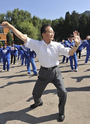 這是溫家寶在學校操場與學生一起打太極拳。 9月10日是第26個教師節(jié),中共中央政治局常委、國務(wù)院總理溫家寶與明年畢業(yè)的北京師范大學首批免費師范生代表一起來到河北省興隆縣六道河中學,看望廣大師生,聽中學教師上課,并與中小學教師和免費師范生代表座談。 新華社記者黃敬文攝