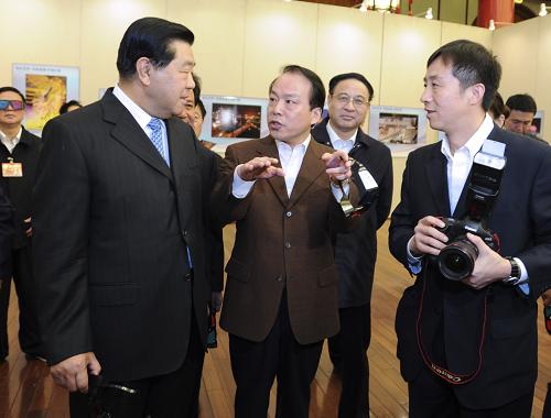 10月20日,中共中央政治局常委、全國政協(xié)主席賈慶林在北京參觀“精彩世博——中國首屆3D圖片展北京巡展”。這是賈慶林在聽取新華社總編輯何平介紹3D照片拍攝原理。 新華社記者謝環(huán)馳攝