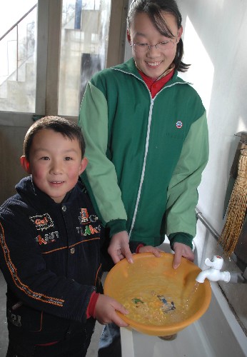 1月13日,高密市闞家鎮(zhèn)王嘉嘉(左)家里的自來水已符合國家標(biāo)準(zhǔn)。當(dāng)日,山東省高密市闞家水廠正式投入使用,這意味著又有34萬農(nóng)村居民喝上了符合國家衛(wèi)生標(biāo)準(zhǔn)的安全水。高密市是全國氟中毒較為嚴(yán)重的地區(qū)之一。為徹底解決當(dāng)?shù)馗叻嬎绊懭罕娊】档膯栴},高密市于2006年6月開始啟動農(nóng)村飲用安全水工程。目前,北部、西部和南部大部分地區(qū)的飲用水工程已完工,54萬農(nóng)村居民喝上了安全的自來水。
