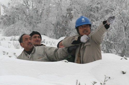 1月22日,安徽金寨縣張沖供電所職工在野外架設(shè)臨時(shí)居民用電線路。