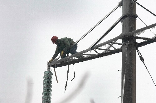 1月23日,一名湖南電力工人正在塔架上除冰。電網(wǎng)保障能力急跌、城鄉(xiāng)停電頻繁,在1月15日持續(xù)至今的罕見冰災(zāi)中,湖南電網(wǎng)遭到重創(chuàng)。連日來,湖南省組織了8000多名電力職工爬冰臥雪,奮戰(zhàn)在除冰保電的第一線。截至23日11時(shí),已經(jīng)成功修復(fù)了包括一條西電東送主通道在內(nèi)的電網(wǎng)設(shè)施。但由于冰災(zāi)持續(xù)并可能惡化,湖南供電形勢依然嚴(yán)峻。