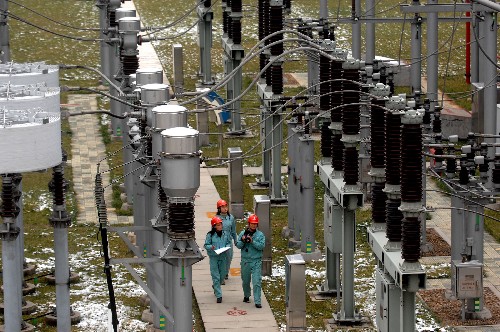 1月24日,供電工作人員冒著嚴寒在安徽宣城敬亭500千伏變電站查看電力設備運行。