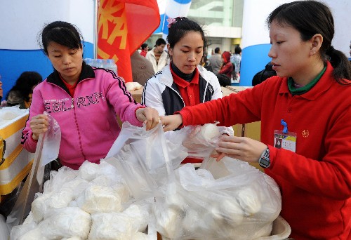 1月29日,青年志愿者在福州火車站為旅客分發(fā)饅頭和豆?jié){。連日的雨雪,給回家過年的旅客帶來了極大的不便,許多旅客滯留車站。福州愛心企業(yè)單位和青年志愿者紛紛為旅客獻愛心,兩天來,福州火車站3萬多名滯留旅客吃上了熱氣騰騰的饅頭和豆?jié){。