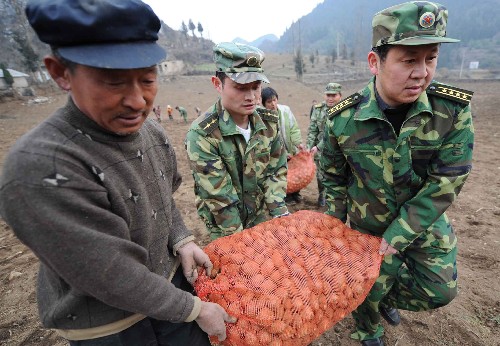 3月3日,貴州省六盤水軍分區(qū)司令員孔?。ㄓ乙唬ьI軍分區(qū)官兵和民兵在水城縣董地鄉(xiāng)中壩村為災民送土豆種。在遭受50年未遇的凝凍災害中,貴州省六盤水軍分區(qū)官兵和20萬民兵不畏嚴寒和辛勞,始終沖鋒在抗災第一線,為六盤水電網(wǎng)恢復、搶運電煤做出了巨大貢獻。在目前正在進行的災后重建工作中,軍分區(qū)官兵和民兵繼續(xù)奮戰(zhàn)在第一線,幫助災民生產(chǎn)自救,力爭把災害帶來的損失降到最低。