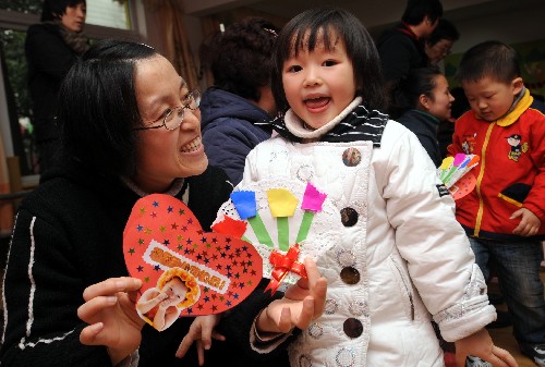 3月6日,杭州朝暉五區(qū)幼兒園的一名孩子(前右)在向媽媽獻上自己制作的愛心賀卡。 在“三八”國際勞動婦女節(jié)即將到來之際,杭州市舉行才藝比拼、愛心傳遞、親子游戲等活動,激發(fā)孩子關(guān)心母親、孝敬長輩的感恩情懷。