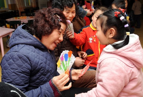 3月6日,杭州朝暉五區(qū)幼兒園的一名孩子(前右)在向奶奶獻上自己制作的愛心賀卡。在“三八”國際勞動婦女節(jié)即將到來之際,杭州市舉行才藝比拼、愛心傳遞、親子游戲等活動,激發(fā)孩子關(guān)心母親、孝敬長輩的感恩情懷。