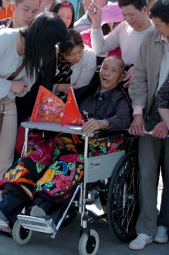 5月12日,泉州市豐澤區(qū)85歲高齡的吳先生在家人的幫助下前來(lái)為火炬?zhèn)鬟f加油。 新華社記者 張生貴 攝