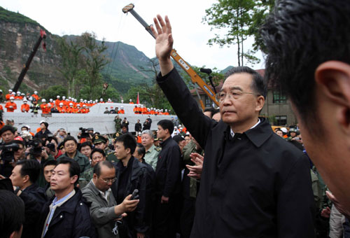 5月14日,國(guó)務(wù)院總理溫家寶抵達(dá)地震重災(zāi)區(qū)四川北川縣察看災(zāi)情。這是溫家寶在北川中學(xué)教學(xué)樓廢墟上看望、慰問(wèn)救援人員。