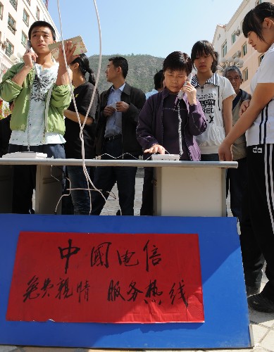 5月14日,甘肅省隴南市文縣城區(qū)居民在免費(fèi)的“親情熱線”前排隊(duì)打電話。 5月12日,與四川省接壤的甘肅省文縣發(fā)生強(qiáng)烈地震后,當(dāng)?shù)仉娦挪块T在城區(qū)設(shè)置了免費(fèi)的親情服務(wù)熱線,讓當(dāng)?shù)鼐用衽c外地的親友保持聯(lián)絡(luò)。