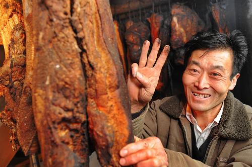 2月24日,寧強(qiáng)縣鐵鎖關(guān)鎮(zhèn)馬家山村村民周定瑞在制作熏肉。陜西省寧強(qiáng)縣是天津市對(duì)口支援的地震重災(zāi)區(qū)。目前,天津援建的2萬多重建戶新房入住率已達(dá)85%,全縣農(nóng)村約15萬間受損房屋全部維修加固,受損的中小學(xué)校舍、鄉(xiāng)鎮(zhèn)衛(wèi)生院等社會(huì)事業(yè)項(xiàng)目均得到新建或全面維修加固,災(zāi)區(qū)群眾安居樂業(yè)、生活穩(wěn)定。