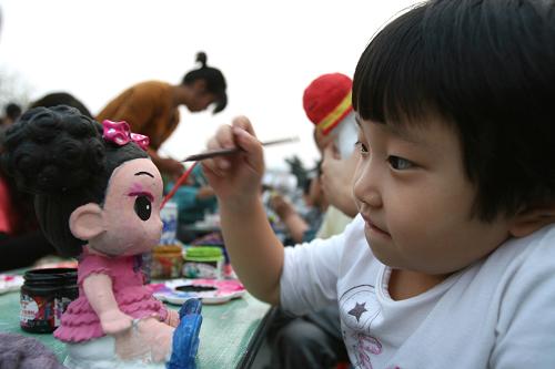 10月6日,一位小游客在安徽阜陽市文峰公園的石膏工藝品展賣會(huì)上為選購的工藝品進(jìn)行彩繪。國慶長假期間,親近自然的鄉(xiāng)村游和各種休閑娛樂活動(dòng)成為人們鐘情的度假方式,“放松”、“愜意”、“開心”正成為長假旅游的關(guān)鍵詞。新華社發(fā)(戴文學(xué) 攝)
