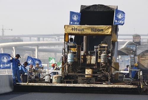 11月26日,工程車輛正在虹橋綜合交通樞紐配套高架路上鋪設(shè)瀝青。當(dāng)日,上海虹橋綜合交通樞紐瀝青攤鋪工程全面啟動(dòng)。包括5條高架道路和21條配套道路在內(nèi)的65.5萬(wàn)平方米路面將鋪設(shè)經(jīng)過(guò)改良的高黏度瀝青,瀝青總量達(dá)18萬(wàn)噸,整個(gè)工程預(yù)計(jì)將于2010年2月完成。上海虹橋綜合交通樞紐是集航空、高鐵、城際軌道、城市軌道、磁懸?。A(yù)設(shè))和地面交通等多種交通方式于一體的綜合性交通樞紐,其建成運(yùn)行后將成為目前世界上最大的綜合交通樞紐。