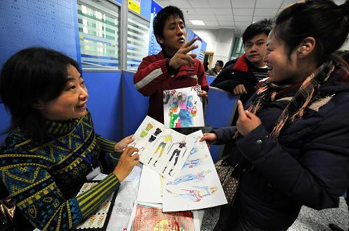 11月27日,一名應聘殘疾人(右一)向用人單位代表展示自己的時裝設計和剪紙等作品。當日,由江蘇省民政廳、省人力資源和社會保障廳、省殘疾人聯(lián)合會主辦的江蘇省殘疾人就業(yè)專場招聘會在南京的江蘇省人才市場舉行,全省近百家社會福利企業(yè)提供管理、財會、電工、車工、裝訂、機械操作等各類工種的上千個崗位,幫助殘疾人就業(yè)。