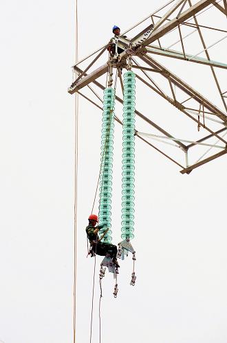 12月1日,福建省第二電力建設(shè)公司員工在福建500千伏電網(wǎng)大環(huán)網(wǎng)“龍三線”上做最后的施工。新華社記者 張國(guó)俊攝
