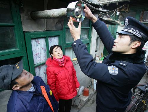 12月3日,民警在社區(qū)內(nèi)為居民安裝煙筒防風(fēng)帽。 當(dāng)日,北京市西城公安分局針對(duì)轄區(qū)部分老舊樓房使用公用煙道和平房居民戶燃煤取暖的特點(diǎn),推出了針對(duì)困難居民試裝試用煤氣報(bào)警器、煙筒防風(fēng)帽等技防產(chǎn)品的舉措。煤氣報(bào)警器可在室內(nèi)煤氣達(dá)到一定程度時(shí),自動(dòng)提示住戶。形狀如同螺絲帽的煙筒防風(fēng)帽,可擋風(fēng)雨,有效避免煤氣倒灌。 新華社記者 袁滿 攝