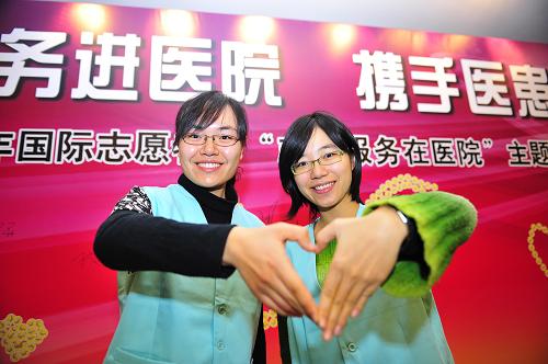12月4日,來自北京大學(xué)醫(yī)學(xué)部的志愿者賈茹(右)和同學(xué)在啟動儀式上打出“愛心”手勢。 當(dāng)日,由衛(wèi)生部、中宣部、教育部、民政部、團(tuán)中央、全國婦聯(lián)、全國總工會、中央文明辦等單位聯(lián)合舉辦的“2009年國際志愿者日‘志愿服務(wù)在醫(yī)院’主題活動”在北京大學(xué)人民醫(yī)院舉行啟動儀式。據(jù)悉,北京大學(xué)人民醫(yī)院志愿者團(tuán)隊(duì)自今年4月份開始工作以來,共開展志愿服務(wù)173天,為醫(yī)院提出合理化建議99條,實(shí)施一系列方便醫(yī)患的服務(wù)舉措,樹立了良好的社會形象。目前,北京大學(xué)人民醫(yī)院共有注冊志愿者416人,其中大多數(shù)是從事醫(yī)療職業(yè)者或在京醫(yī)學(xué)院校的學(xué)生。12月5日是第24個國際志愿者日。 新華社記者 楊光 攝