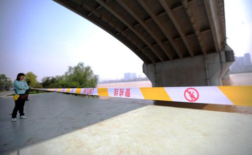 4月23日,長(zhǎng)沙橘子洲上一位游客在警戒線外看湘江。湖南省4月連續(xù)發(fā)生較大降雨過(guò)程,湘江水位持續(xù)上漲。湖南省水文水資源勘測(cè)局?jǐn)?shù)據(jù)顯示,4月1日至今,湘江長(zhǎng)沙段水位已上升9米多,23日下午14時(shí),水位達(dá)到36.1米,超過(guò)了36米的警戒水位,預(yù)計(jì)湘江長(zhǎng)沙段將于24日5時(shí)出現(xiàn)洪峰,洪峰水位在36.3米以上,相應(yīng)流量16300立方米/秒。目前,橘子洲景區(qū)靠近江邊的環(huán)洲游步道已被江水淹沒(méi),近水位置的樹木等植被也浸泡在江水中。為保障游客安全,景區(qū)在游道邊拉起了警戒線防止游客靠近江水,景區(qū)的關(guān)閉時(shí)間也從晚上的22點(diǎn)提前到傍晚18點(diǎn)。